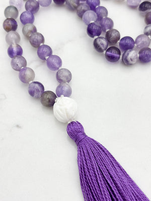 amethyst gemstone mala with carved tridacna shell guru bead and purple tassel | radiant malas | handmade in boulder, colorado