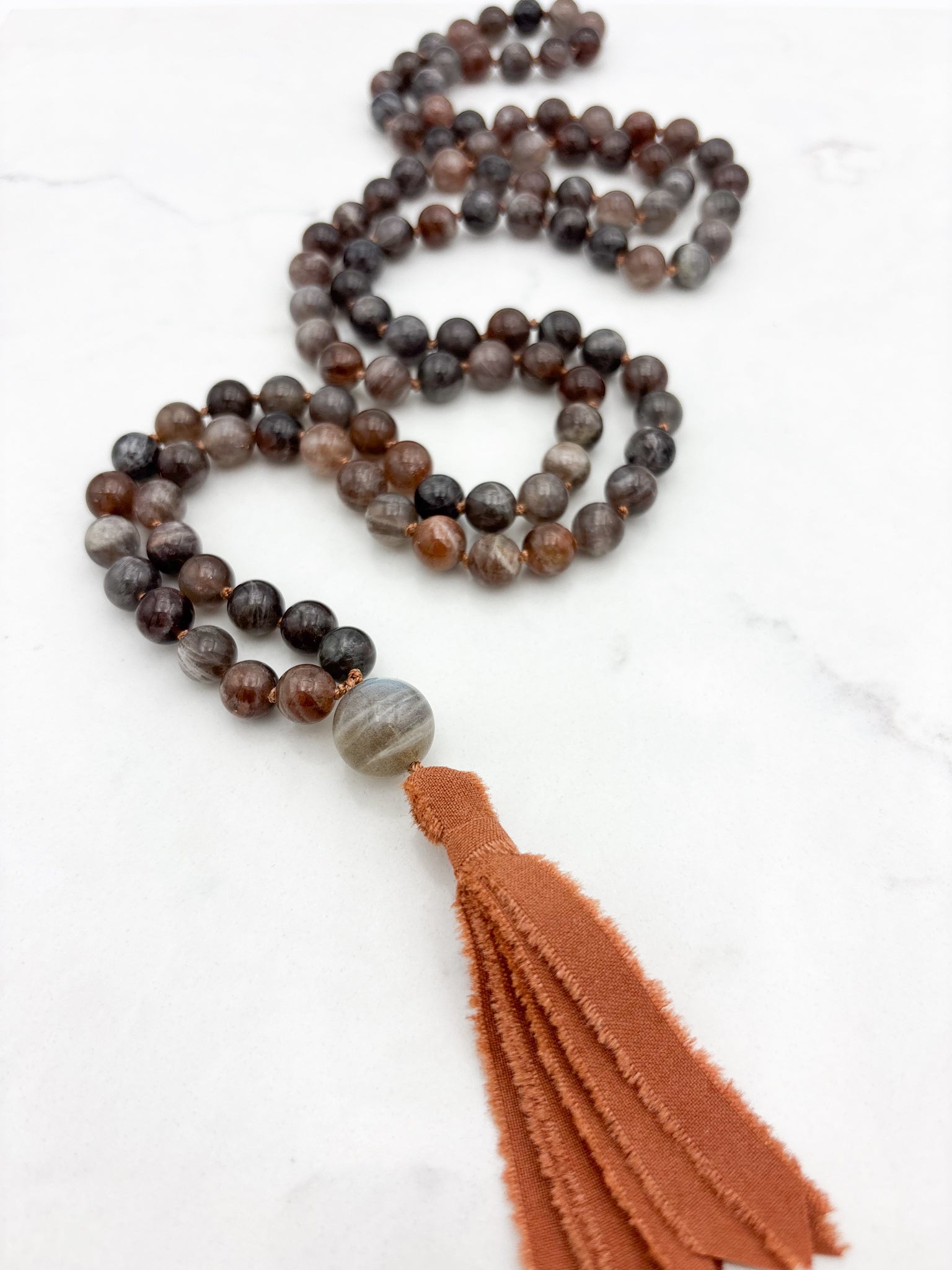 black sunstone gemstone mala with labradorite guru bead and rust colored silk tassel | radiant malas | handmade in boulder, colorado
