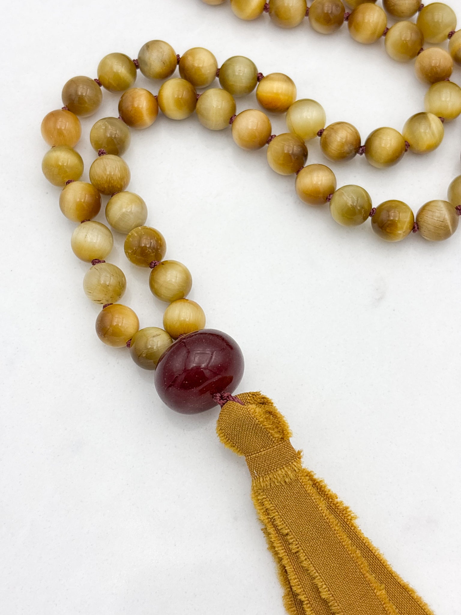 blond tiger's eye gemstone mala necklace with cherry agate guru bead and ochre silk tassel  | radiant malas | handmade in boulder, colorado