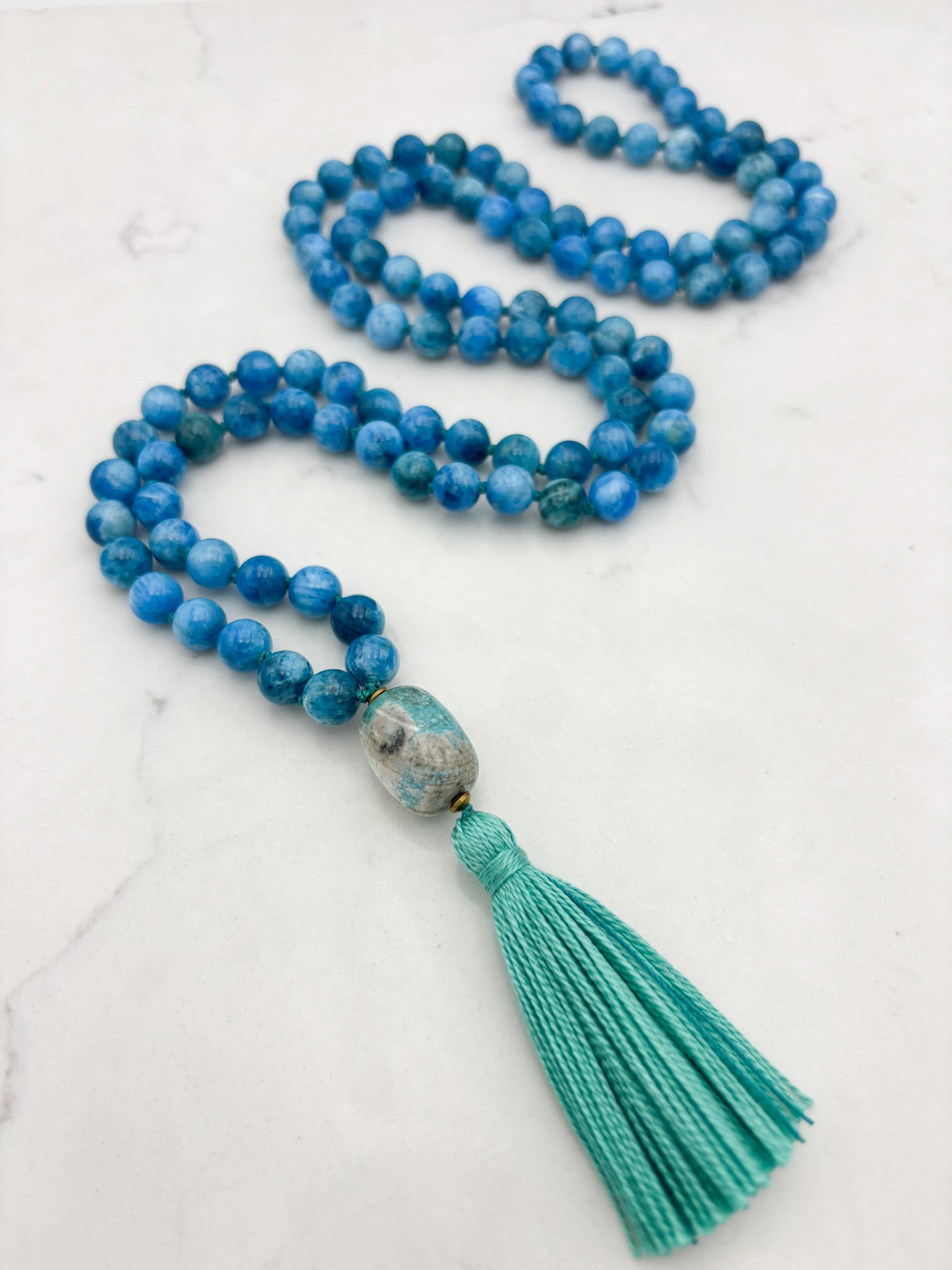 blue apatite gemstone mala with ceramic guru bead and teal tassel | radiant malas | handmade in boulder, colorado