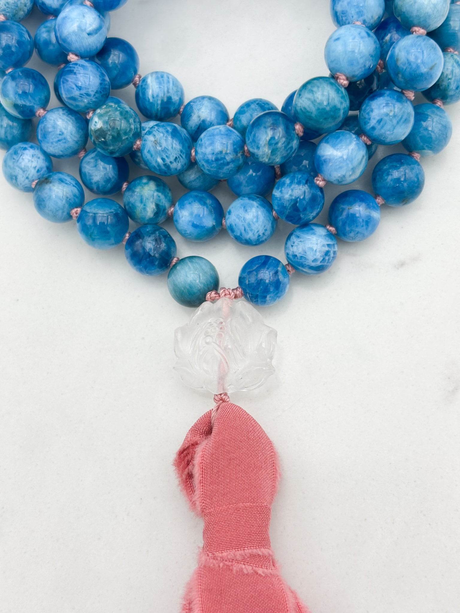 blue apatite gemstone mala with lotus-carved clear quartz guru bead and pinnk silk tassel | radiant malas | handmade in boulder, colorado