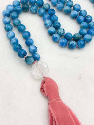 blue apatite gemstone mala with lotus-carved clear quartz guru bead and pinnk silk tassel | radiant malas | handmade in boulder, colorado