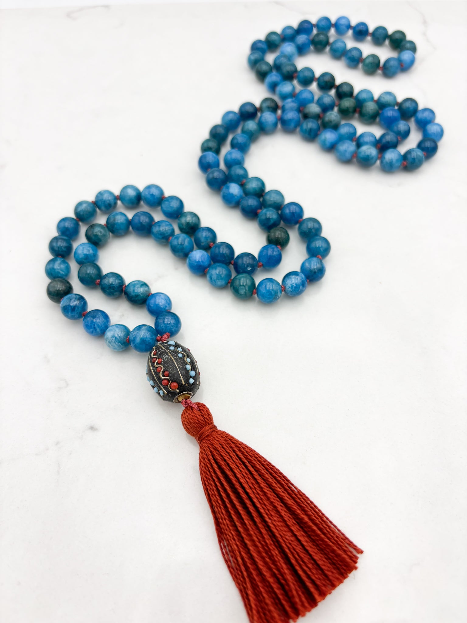 blue apatite gemstone mala necklace with Tibetan guru bead and rust tassel | radiant malas | handmade in boulder, colorado
