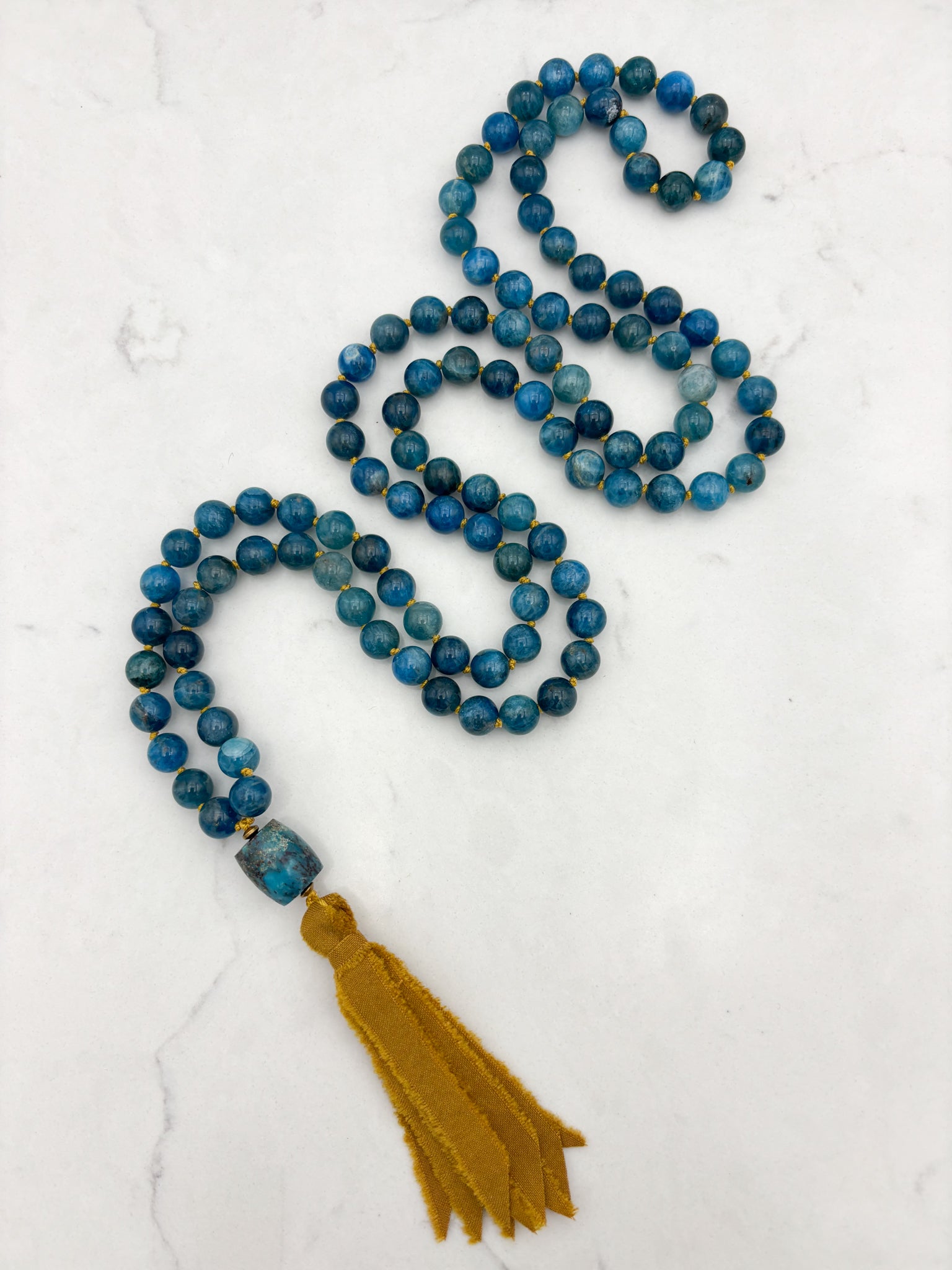 blue apatite gemstone mala with turquoise guru bead and ochre silk ribbon tassel | radiant malas | handmade in boulder, colorado