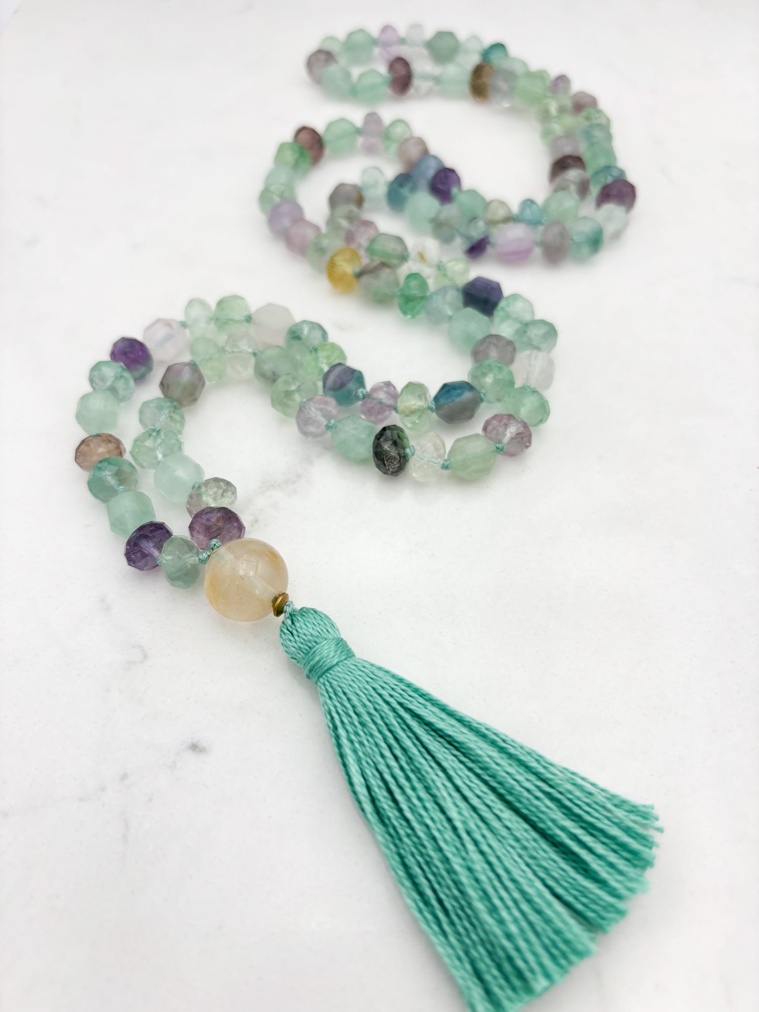 fluorite gemstone mala with golden quartz guru bead and mint green tassel | radiant malas  handmade in boulder, colorado