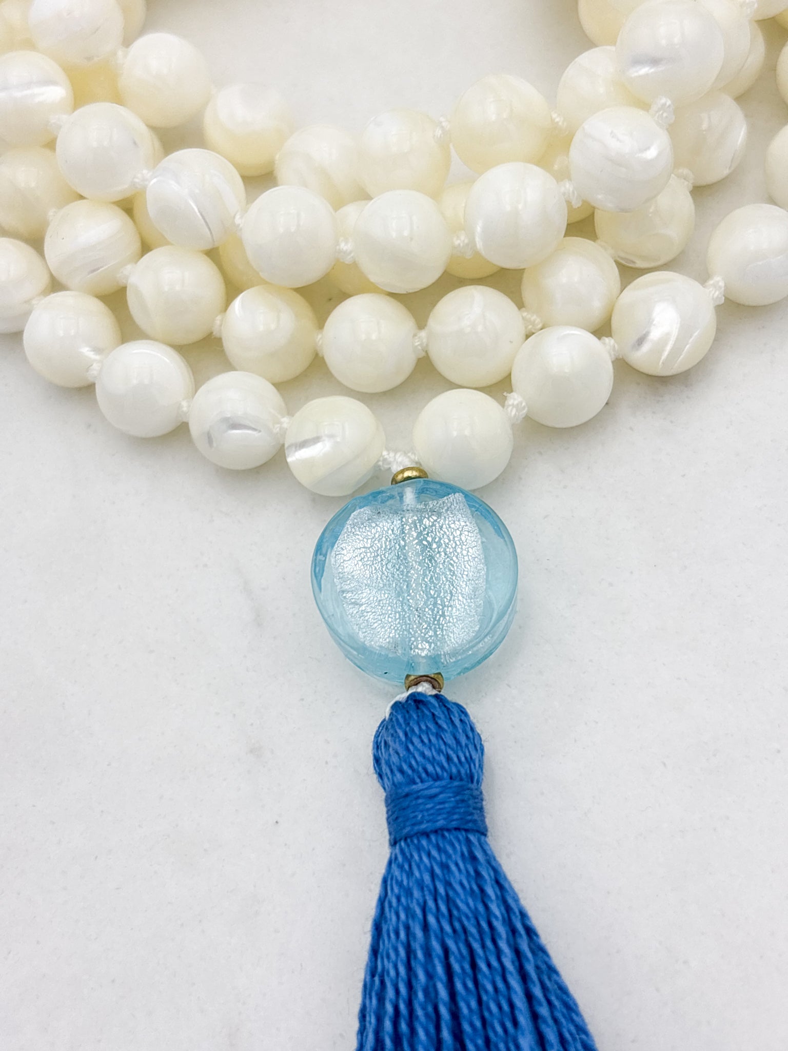mother of pearl gemstone mala with blue lampwork glass guru bead and blue tassel | radiant malas | handmade in boulder, colorado