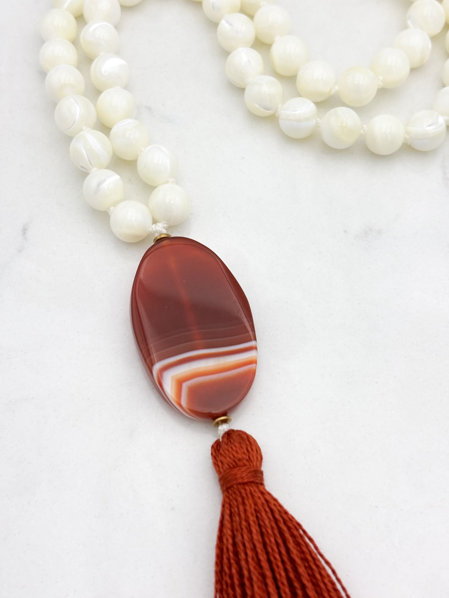 mother of pearl gemstone mala with red botswana agate guru bead and rust tassel | radiant malas | handmade in boulder, colorado