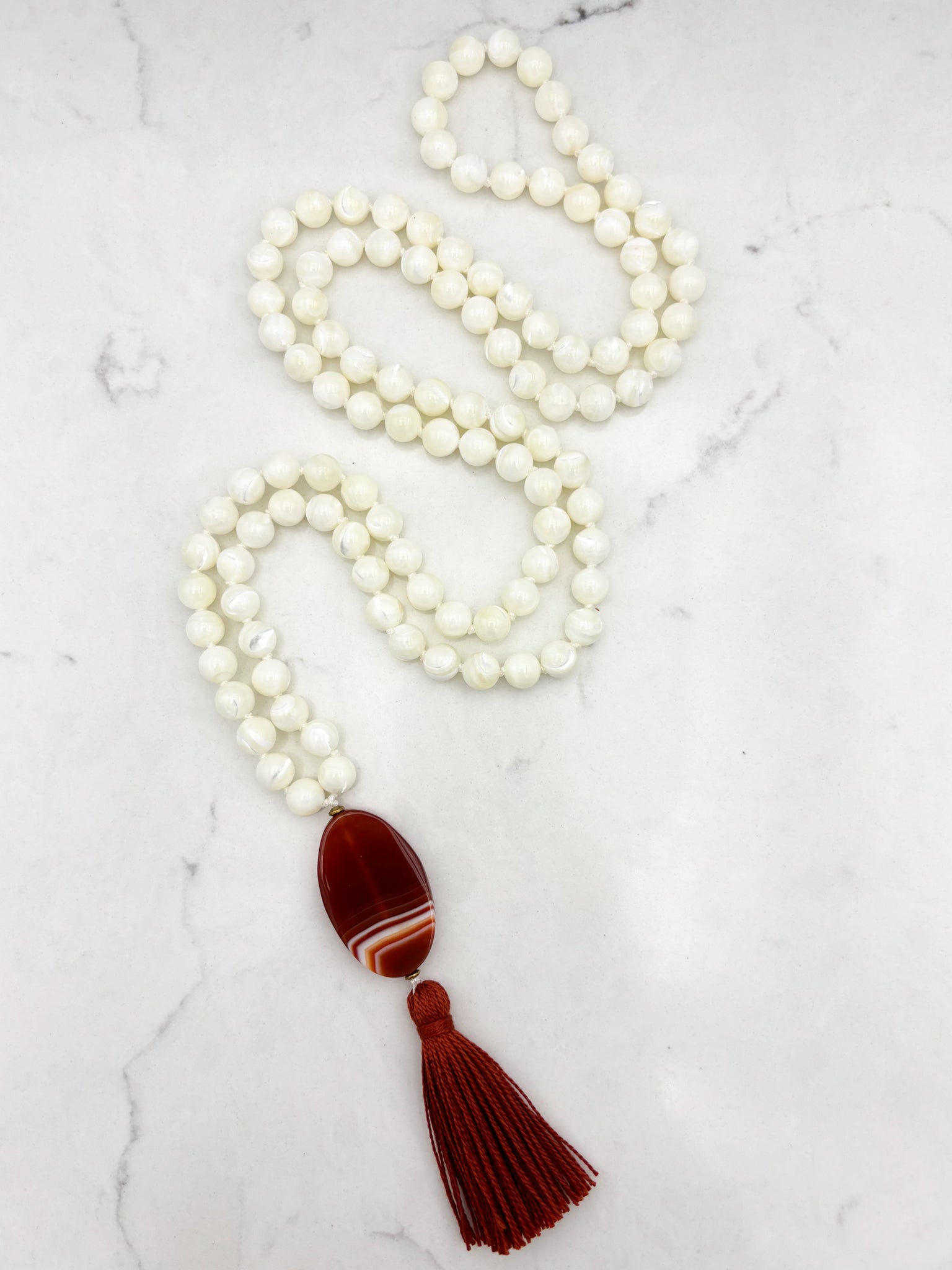 mother of pearl gemstone mala with red botswana agate guru bead and rust tassel | radiant malas | handmade in boulder, colorado
