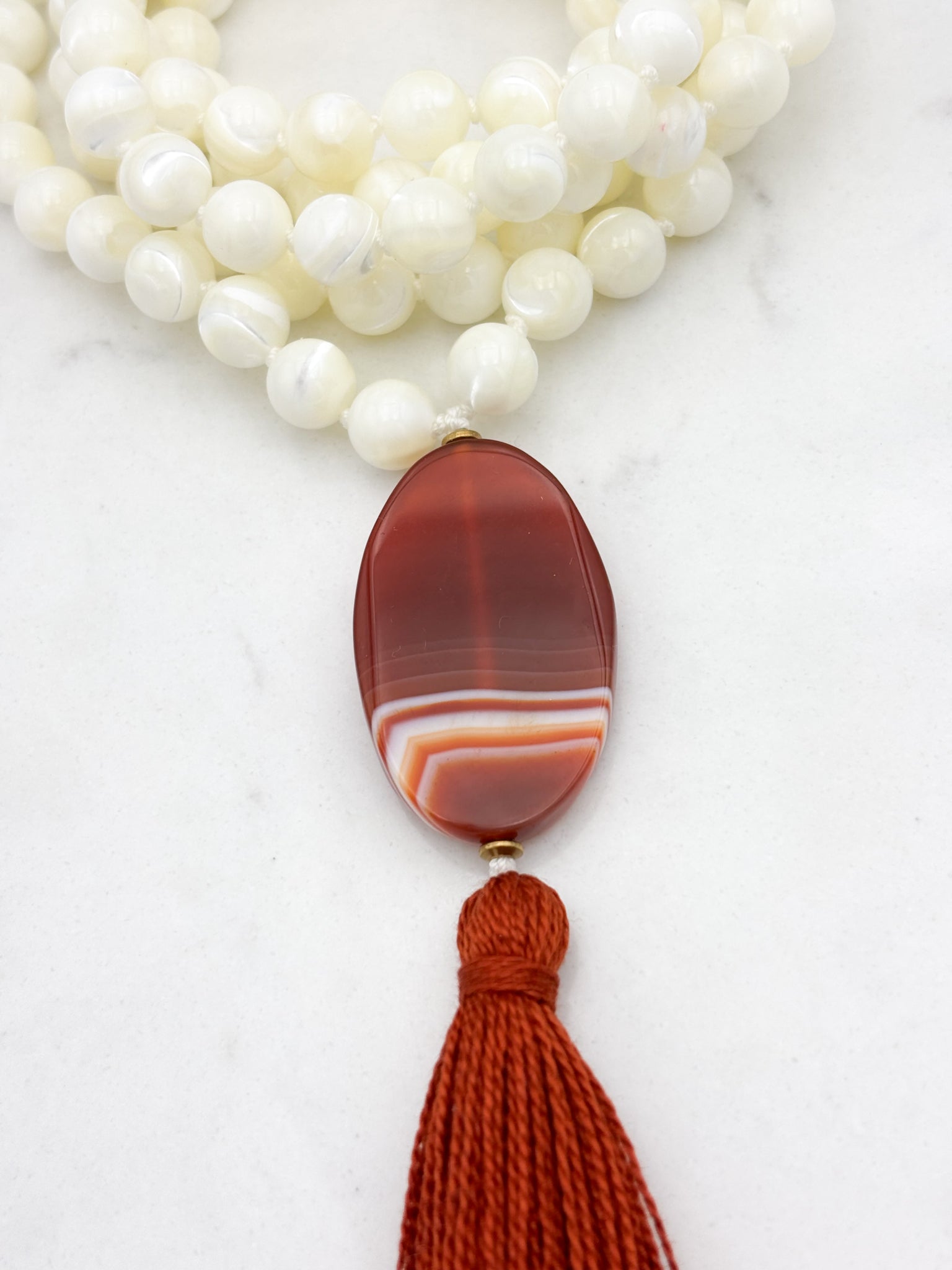 mother of pearl gemstone mala with red botswana agate guru bead and rust tassel | radiant malas | handmade in boulder, colorado