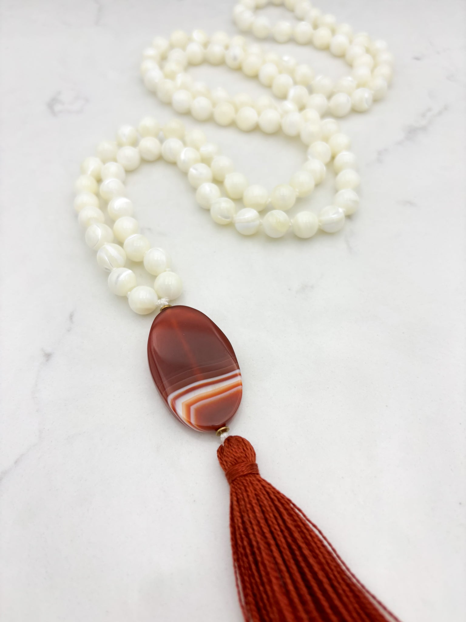 mother of pearl gemstone mala with red botswana agate guru bead and rust tassel | radiant malas | handmade in boulder, colorado
