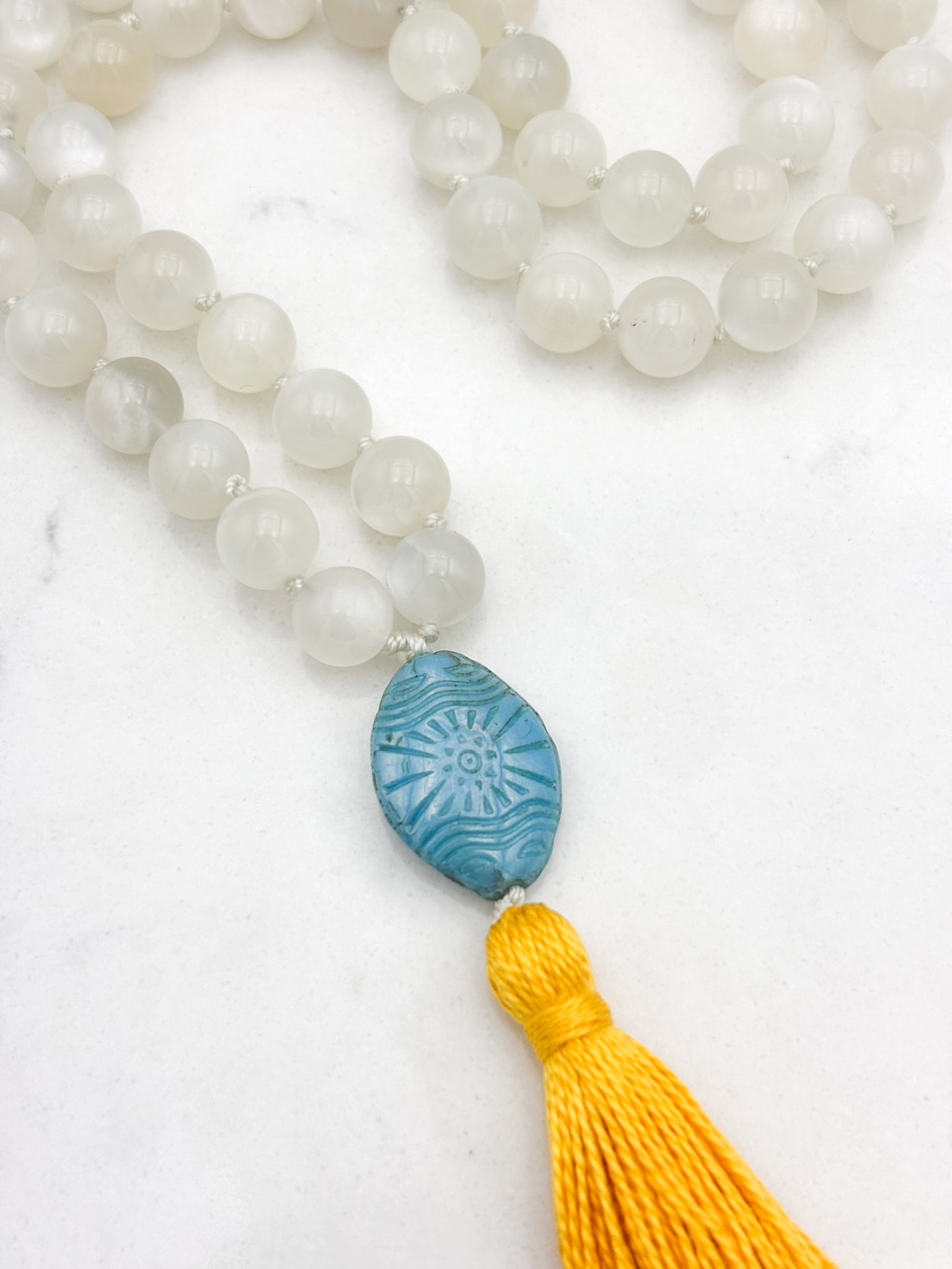 moonstone gemstone mala necklace with carved blue glass guru bead and yellow tassel | handmade in boulder, colorado | radiant malas