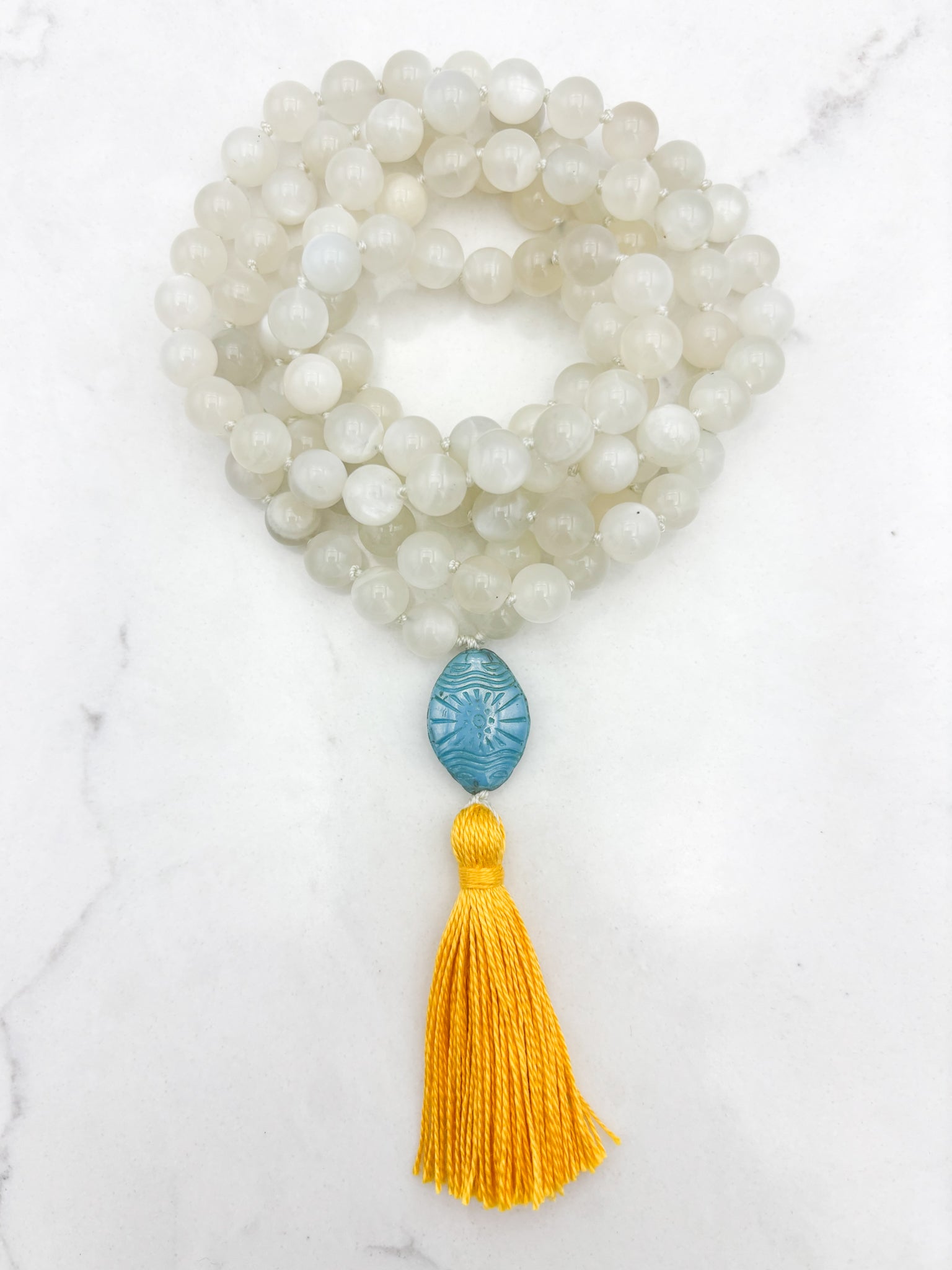 moonstone gemstone mala necklace with carved blue glass guru bead and yellow tassel | handmade in boulder, colorado | radiant malas
