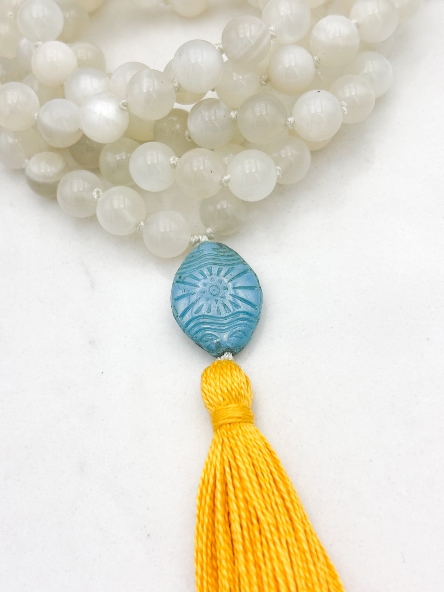 moonstone gemstone mala necklace with carved blue glass guru bead and yellow tassel | handmade in boulder, colorado | radiant malas