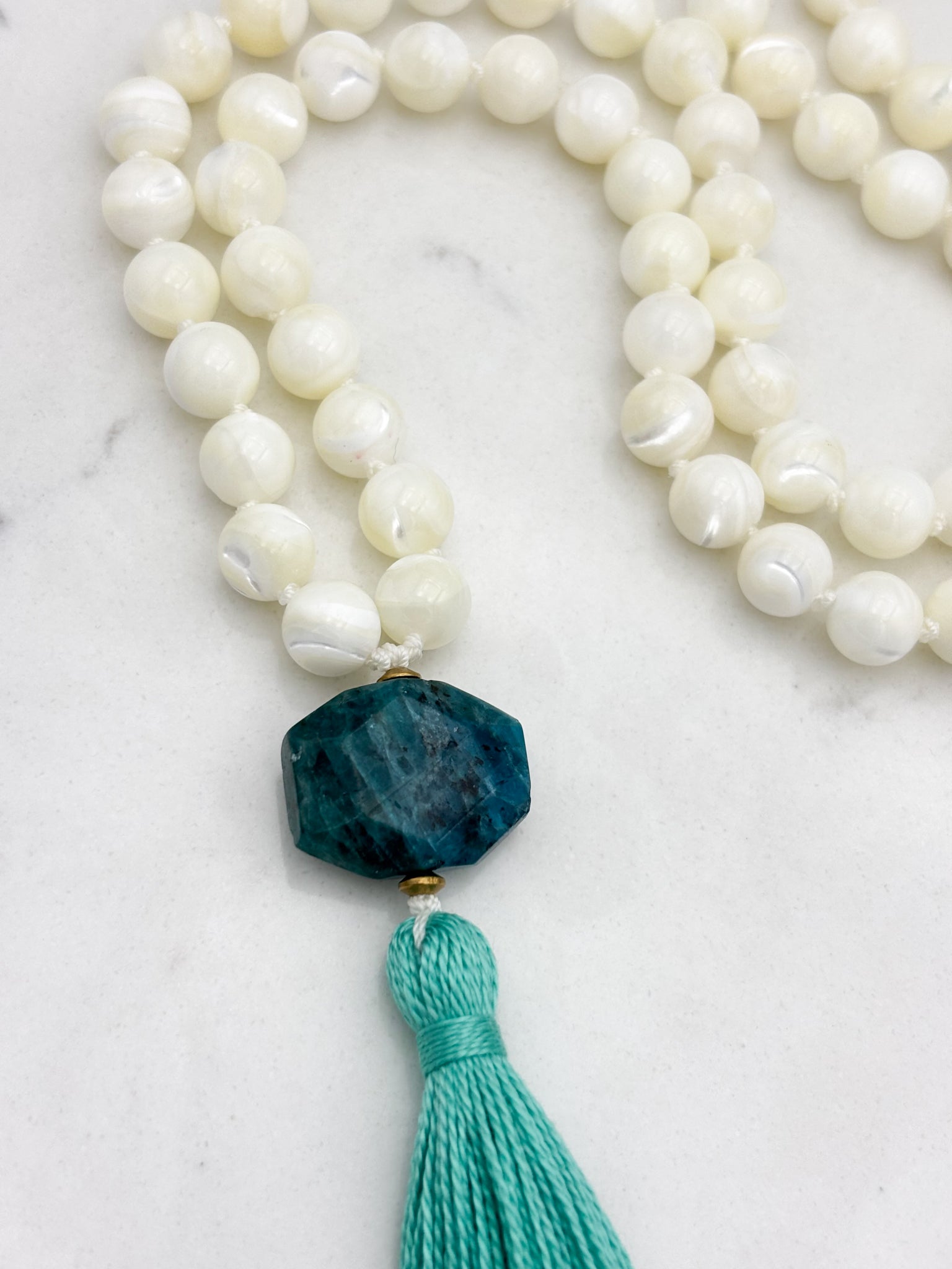mother of pearl gemstone mala with blue apatite guru bead and teal tassel 
| radiant malas | handmade in boulder, colorado