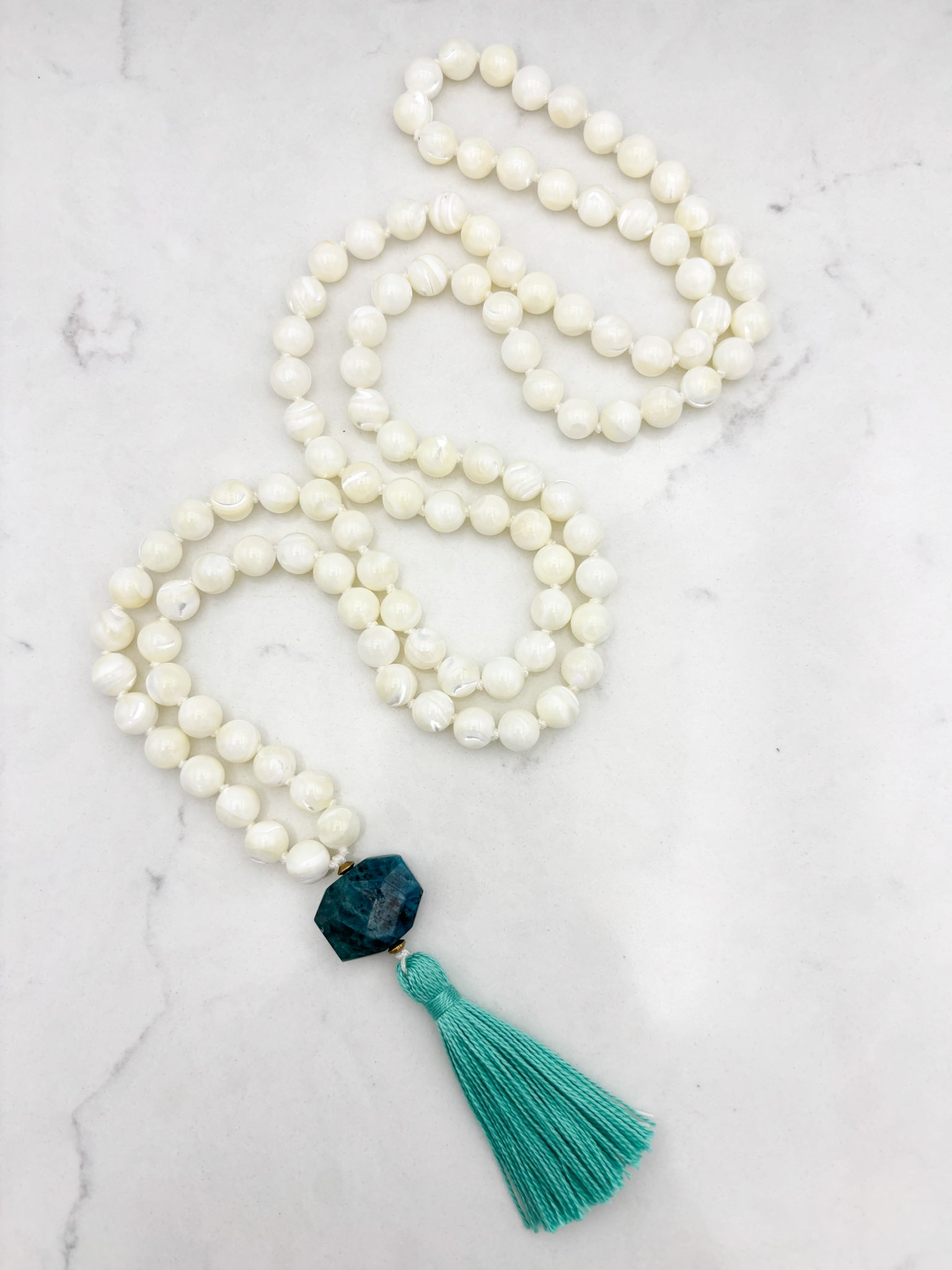mother of pearl gemstone mala with blue apatite guru bead and teal tassel 
| radiant malas | handmade in boulder, colorado