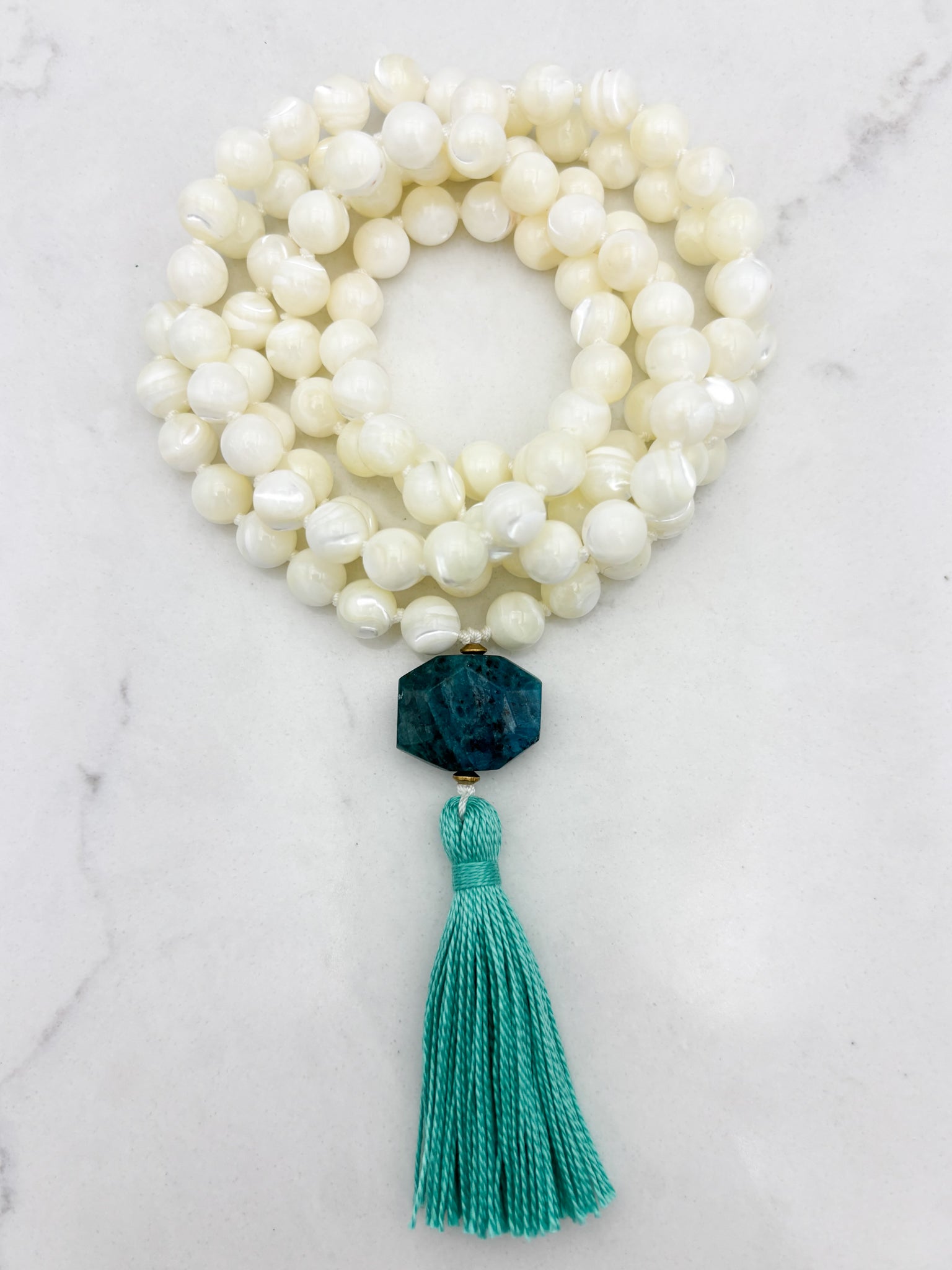 mother of pearl gemstone mala with blue apatite guru bead and teal tassel 
| radiant malas | handmade in boulder, colorado
