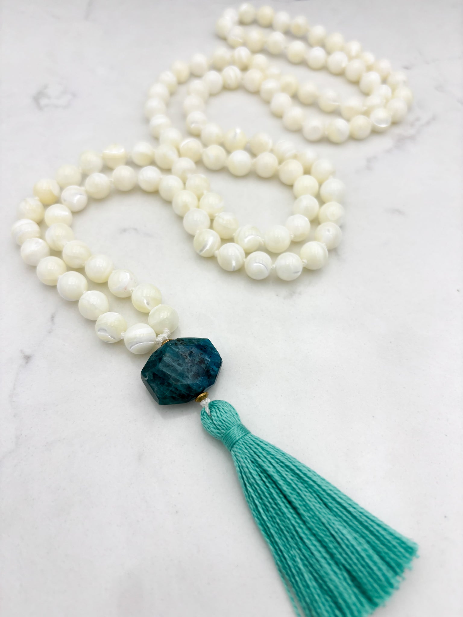 mother of pearl gemstone mala with blue apatite guru bead and teal tassel 
| radiant malas | handmade in boulder, colorado