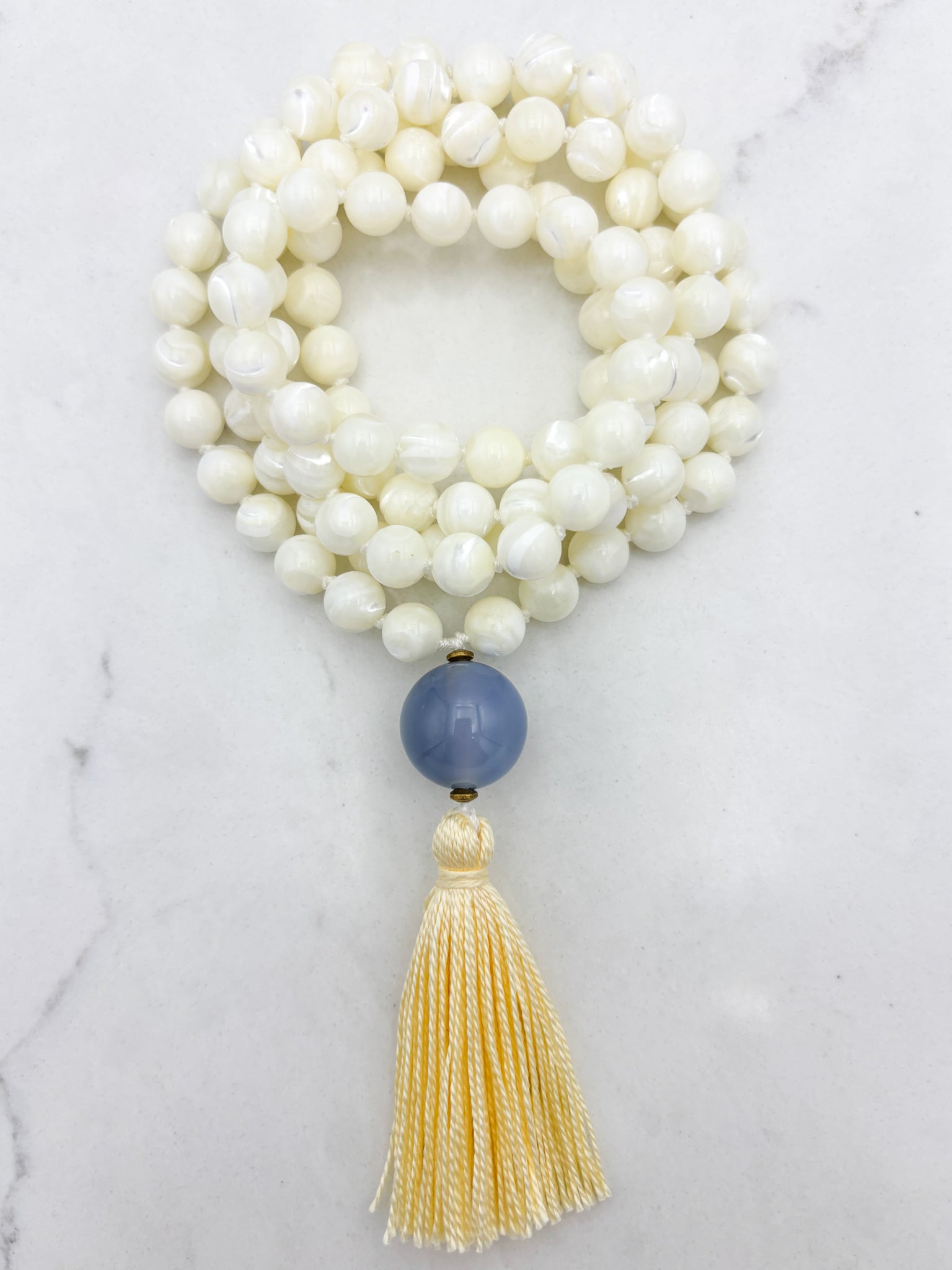 mother of pearl gemstone mala with chalcedony guru bead and pale yellow tassel | radiant malas | handmade in boulder, colorado