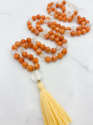 orange calcite with clear quartz gemstone mala with clear lampwork glass guru bead and yellow tassel | radiant malas | handmade in boulder, colorado