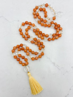 orange calcite with clear quartz gemstone mala with clear lampwork glass guru bead and yellow tassel | radiant malas | handmade in boulder, colorado