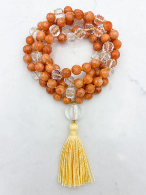 orange calcite with clear quartz gemstone mala with clear lampwork glass guru bead and yellow tassel | radiant malas | handmade in boulder, colorado