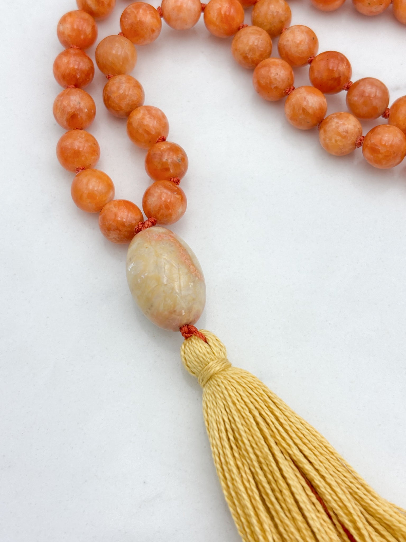 orange calcite gemstone mala with fossil coral guru bead and yellow tassel | radiant malas | handmade in boulder, colorado