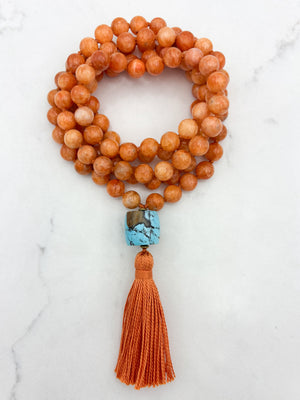 orange calcite gemstone mala with turquoise guru bead and orange tassel | radiant malas | handmade in boulder, colorado