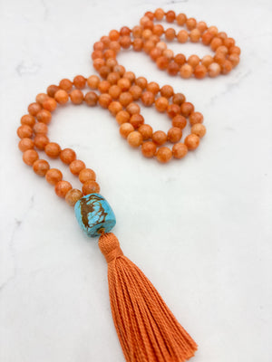 orange calcite gemstone mala with turquoise guru bead and orange tassel | radiant malas | handmade in boulder, colorado