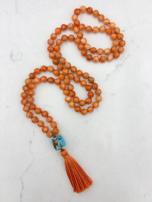orange calcite gemstone mala with turquoise guru bead and orange tassel | radiant malas | handmade in boulder, colorado