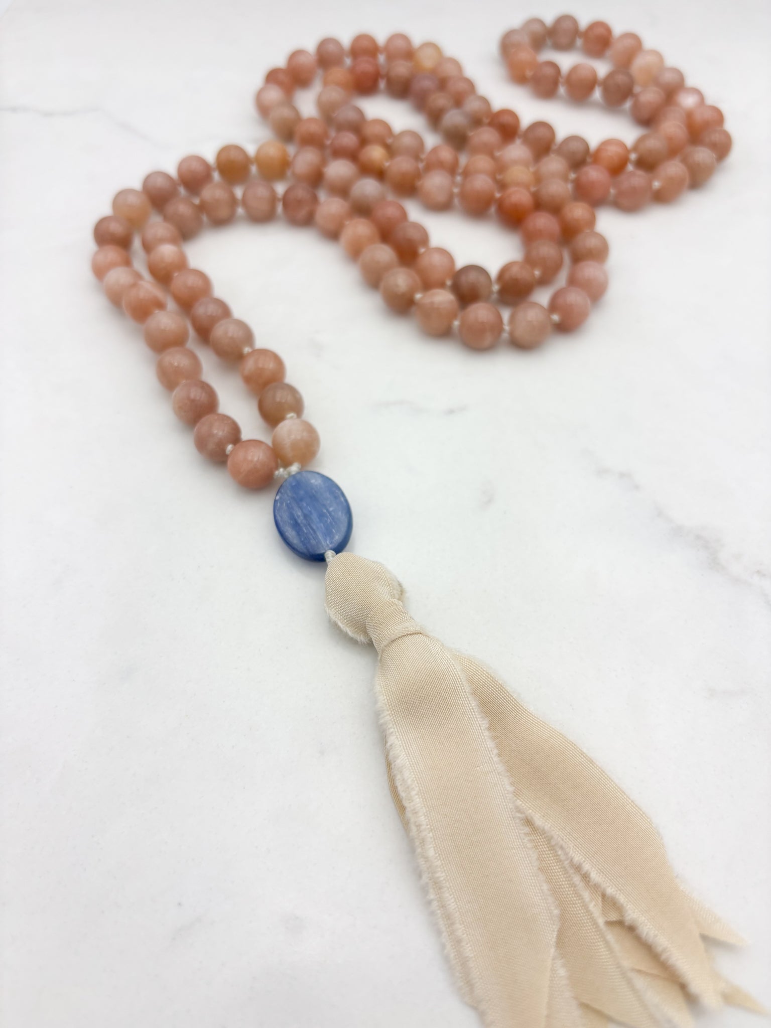 peach moonstone gemstone mala with kyanite guru bead and cream silk  tassel | radiant malas | handmade in boulder, colorado