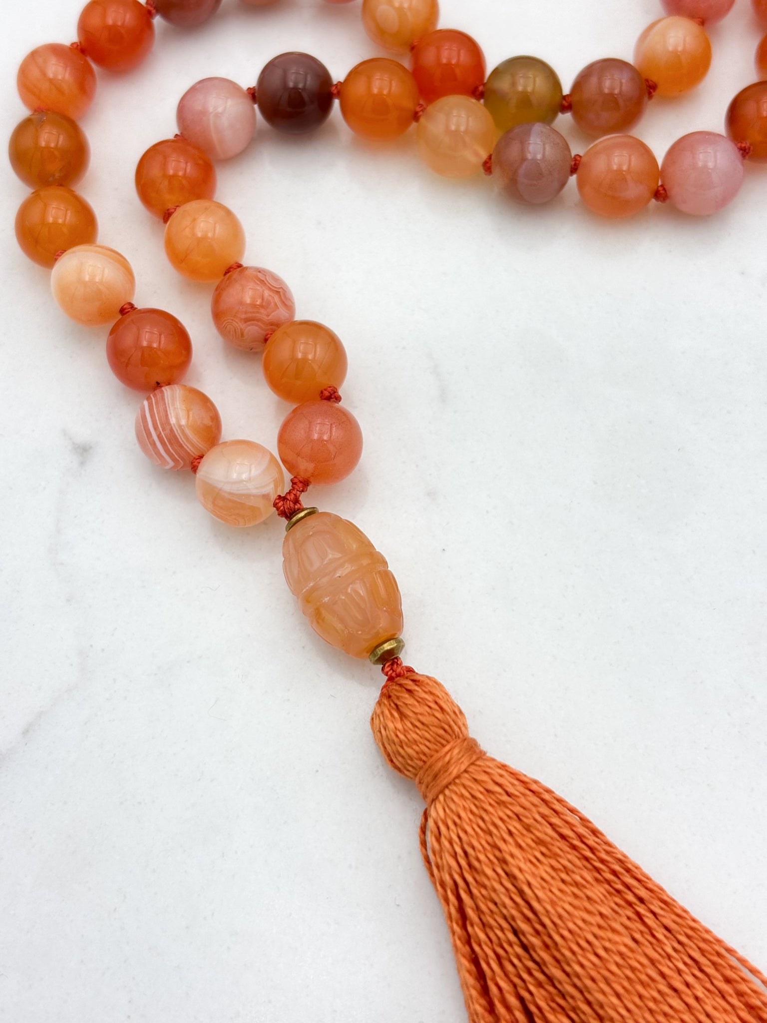 Red Botswana Agate Gemstone Mala with carved carnelain guru bead and orange tassel | radiant malas | handmade in Boulder, colorado