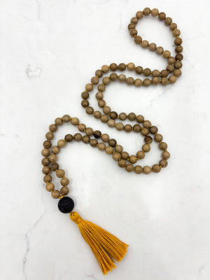 Meditation necklace with wooden beads, a black guru bead, and a yellow tassel | radiant malas | handmade in boulder, colorado