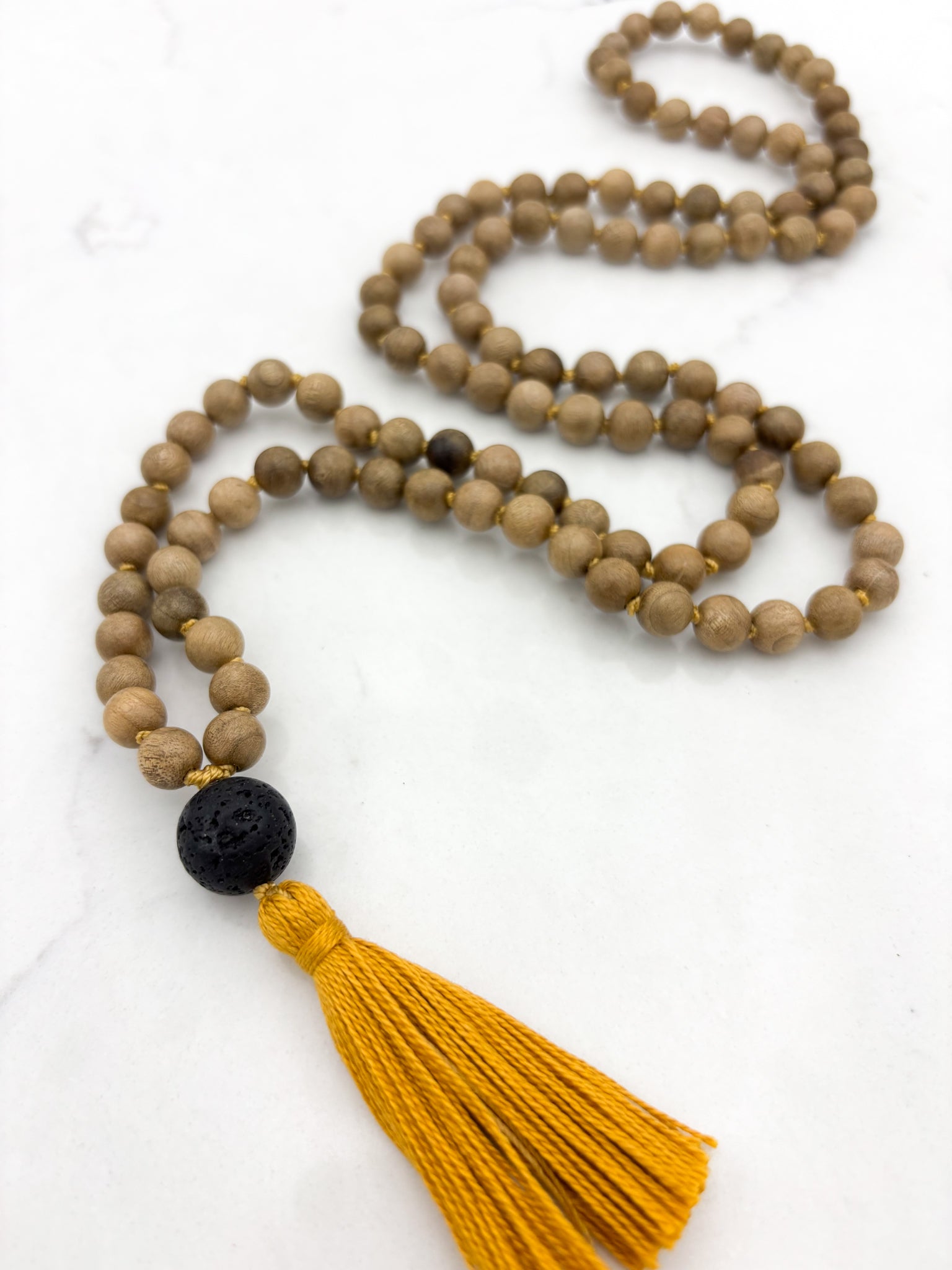 Meditation necklace with wooden beads, a black guru bead, and a yellow tassel | radiant malas | handmade in boulder, colorado
