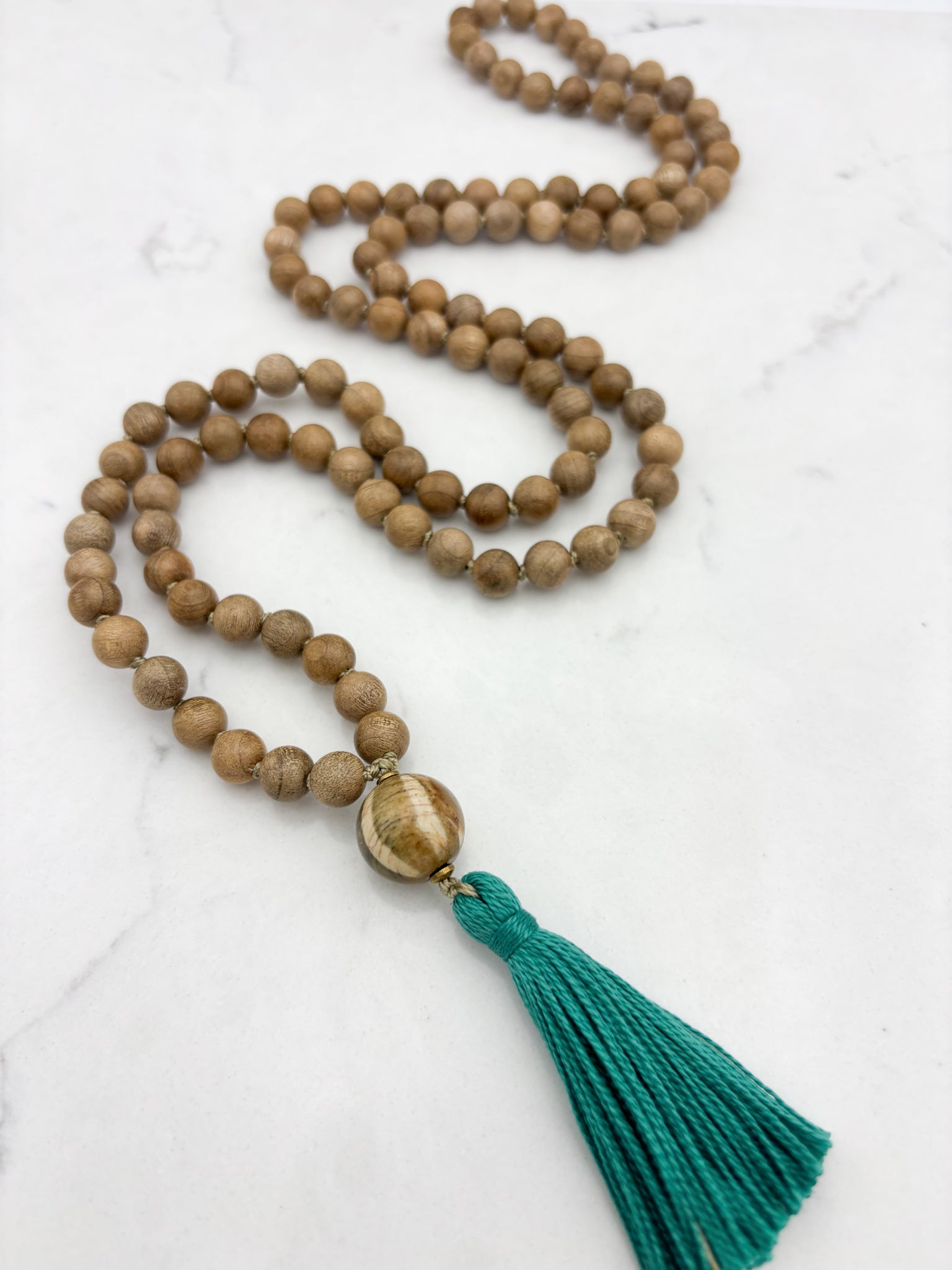 Sandalwood mala meditation necklace with wood guru bead and a green tassel | radiant malas | handmade in boulder, colorado