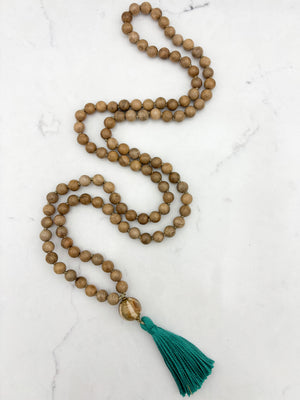 Sandalwood mala meditation necklace with wood guru bead and a green tassel | radiant malas | handmade in boulder, colorado