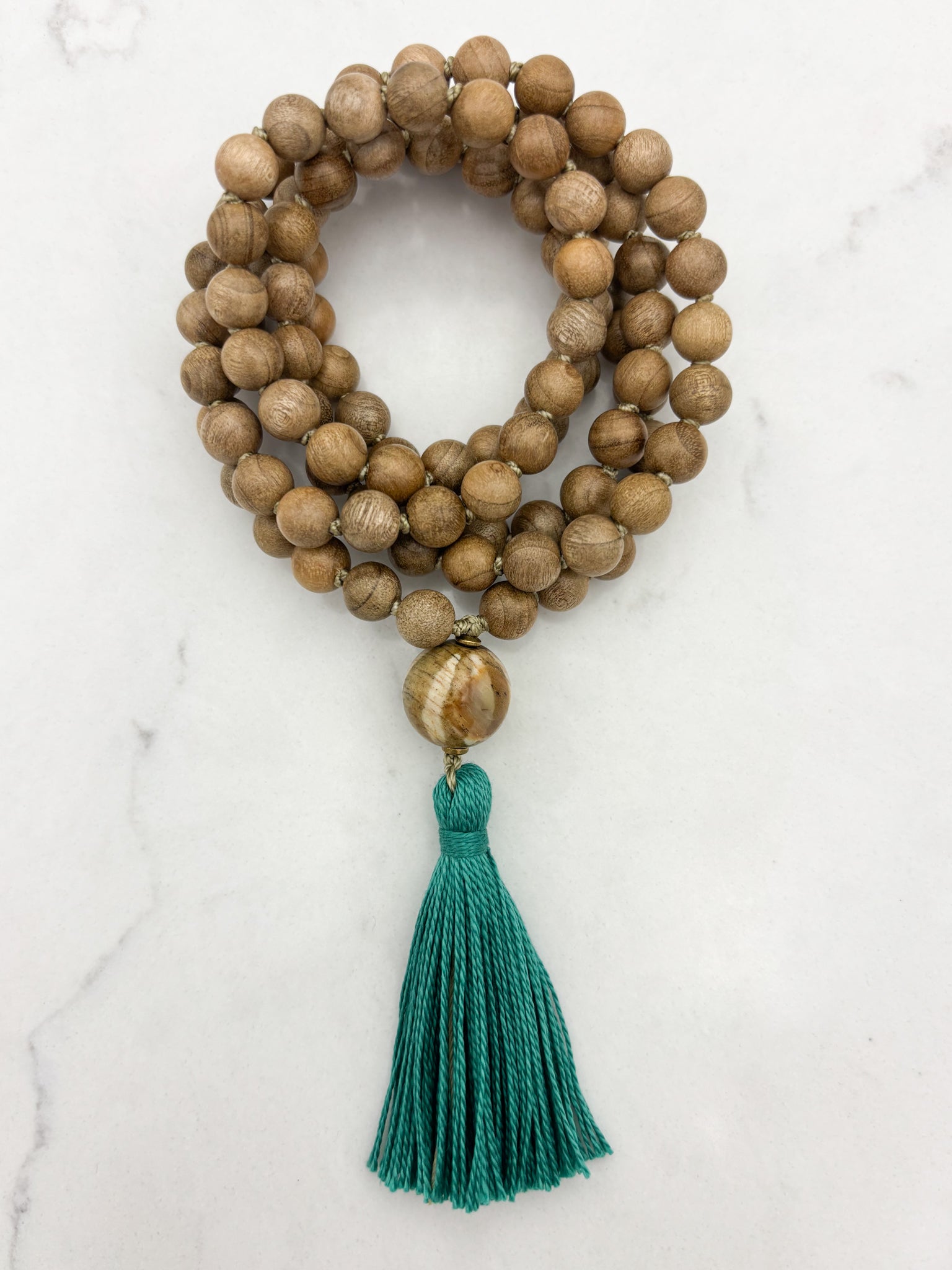 Sandalwood mala meditation necklace with wood guru bead and a green tassel | radiant malas | handmade in boulder, colorado