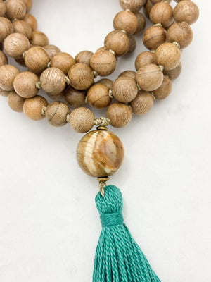 Sandalwood mala meditation necklace with wood guru bead and a green tassel | radiant malas | handmade in boulder, colorado
