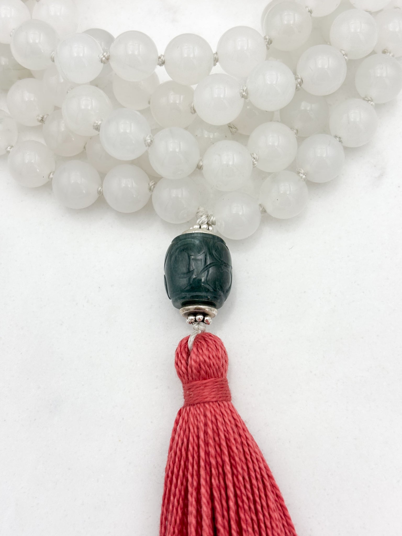 white jade gemstone mala necklace with carved green jade guru bead and pink tassel | radiant malas | handmade in boulder, colorado