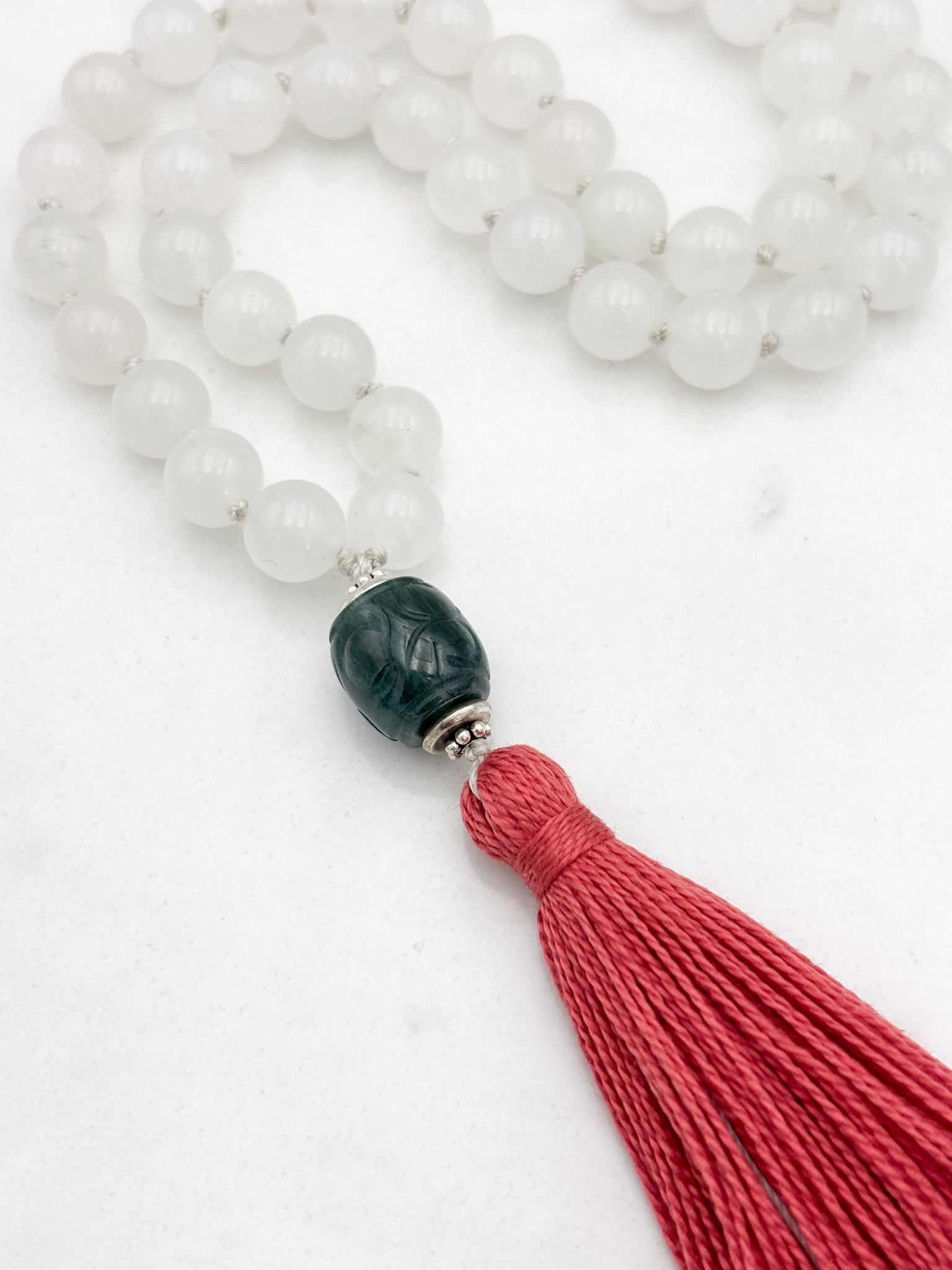 white jade gemstone mala necklace with carved green jade guru bead and pink tassel | radiant malas | handmade in boulder, colorado