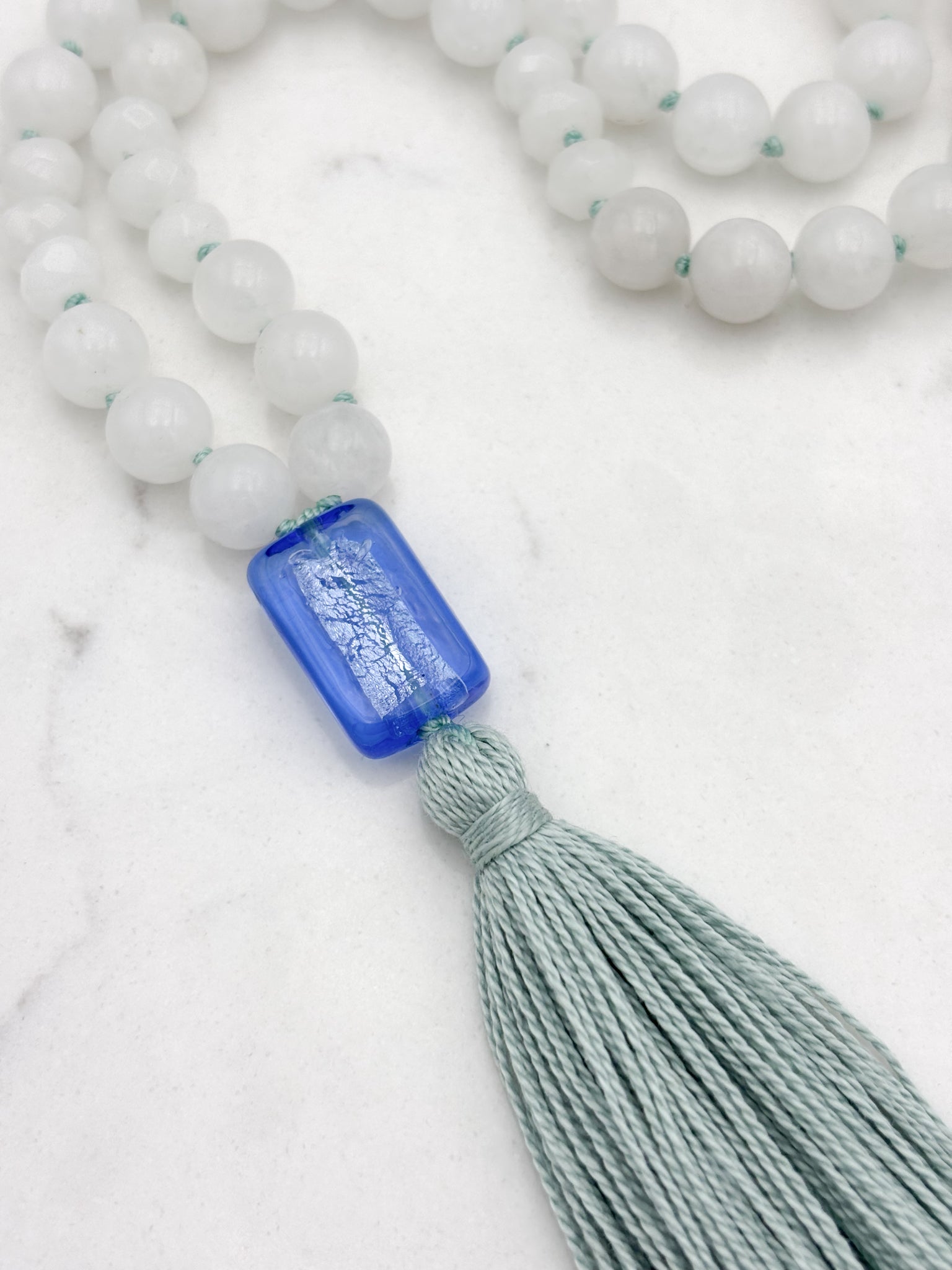 white jade gemstone mala necklace with blue lampwork glass guru bead and seafoam green tassel | radiant malas | handmade in boulder, colorado